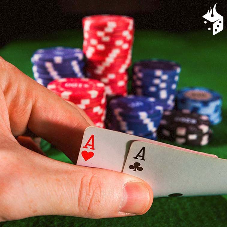 dark bluff poker Mão segurando dois ases e fichas de poker sobre a mesa.