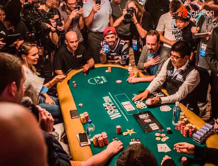 mtt wsop poker jogadores de poker em uma mesa da WSOP, cercadas por pessoas tirando fotos.