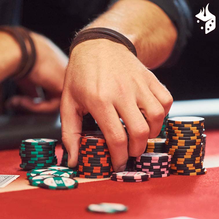 poker mtt torneios mão colocando fichas por cima de fichas em uma mesa de poker.