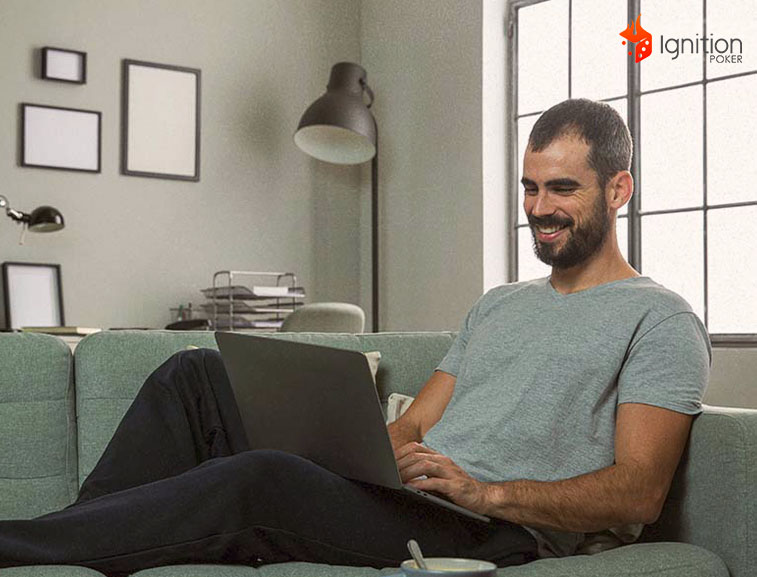 conforto cassino online Homem sentado de frente do computador sorrindo