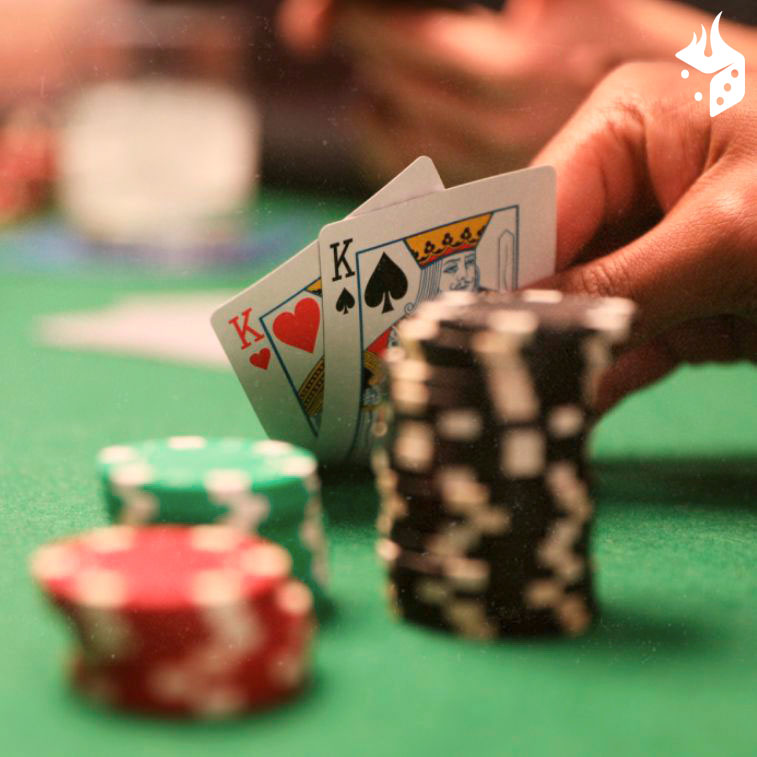 poker online natal Mão com dois reis e fichas de poker sobre uma mesa